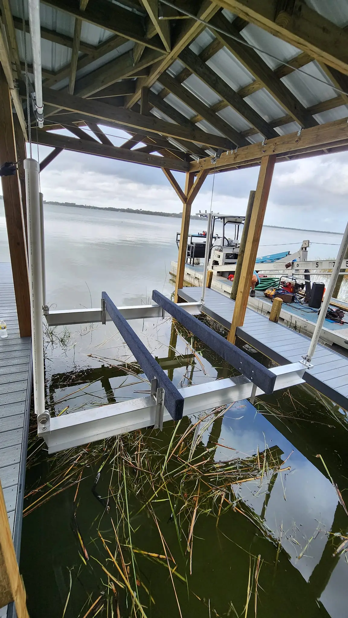 Aluminum boat lift cradle with bunks in a covered slip on a lake