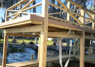 Boathouse frame under construction with an upper deck railing over a canal