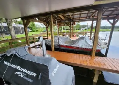 Covered boathouse with a WaveRunner and a covered boat on lifts