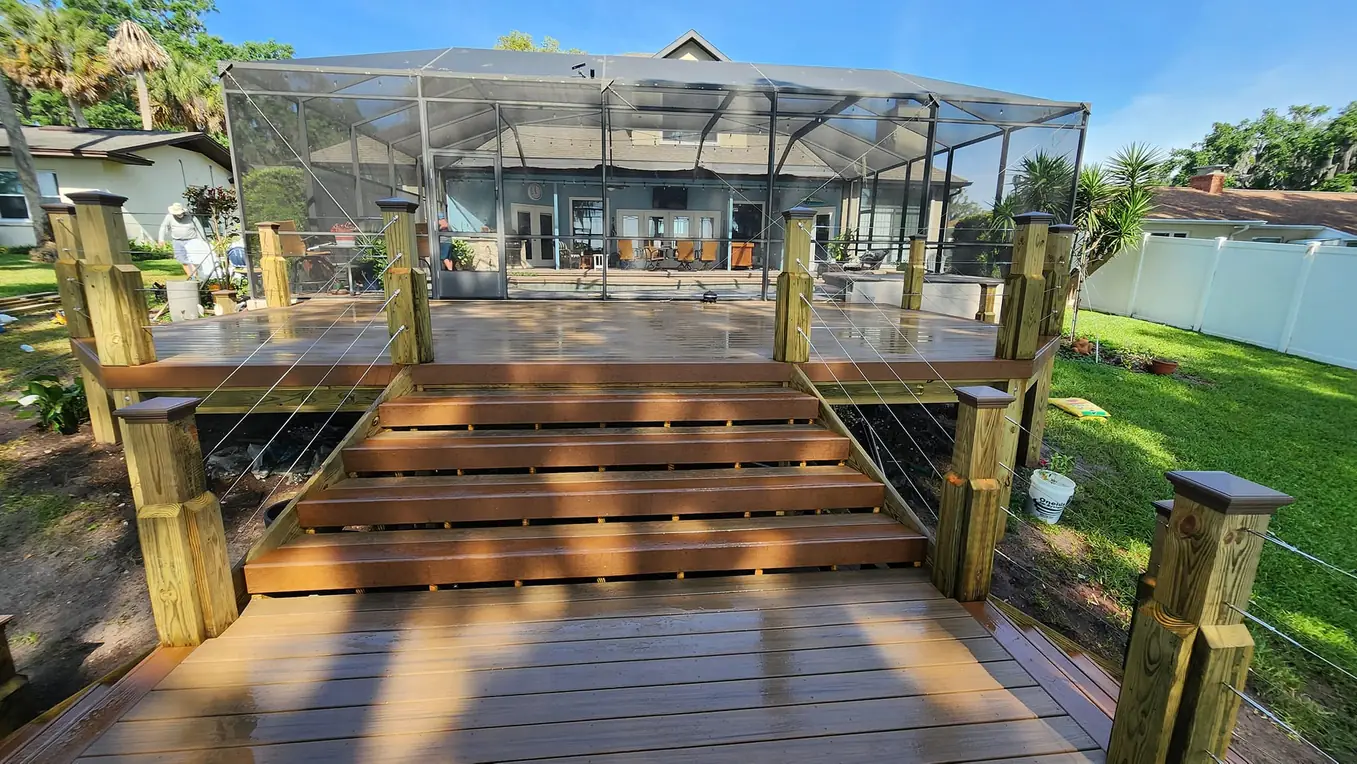 Wide composite deck steps leading to a pool screen enclosure