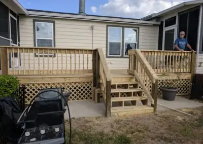 Wooden porch with steps, railing and lattice skirting on a manufactured home