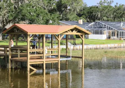 Covered dock with a red metal roof on a lake