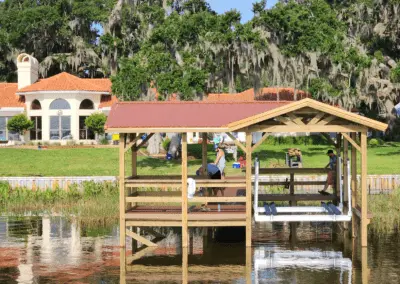 Covered boat lift with a red roof on a lakefront