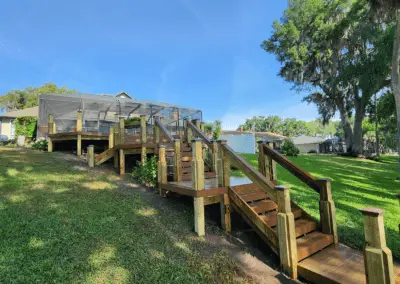 Multi-level wooden deck and stairs down a sloped lawn