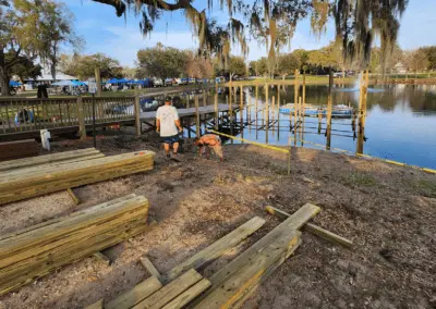 Crew staging lumber on a lakefront dock construction site