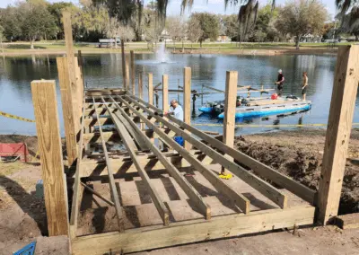 Dock frame under construction with joists and posts on a lakefront