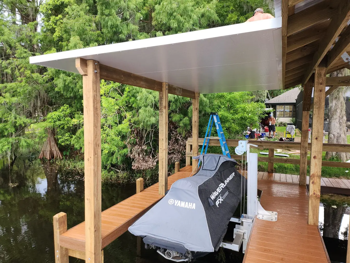 Yamaha WaveRunner on a lift beside a dock under a new metal roof